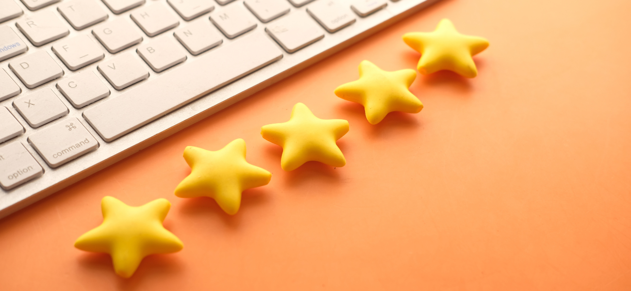 Znak jakości 5 gwiazdek obok klawiatury komputera symbolizuje jakość w technologii e-commerce